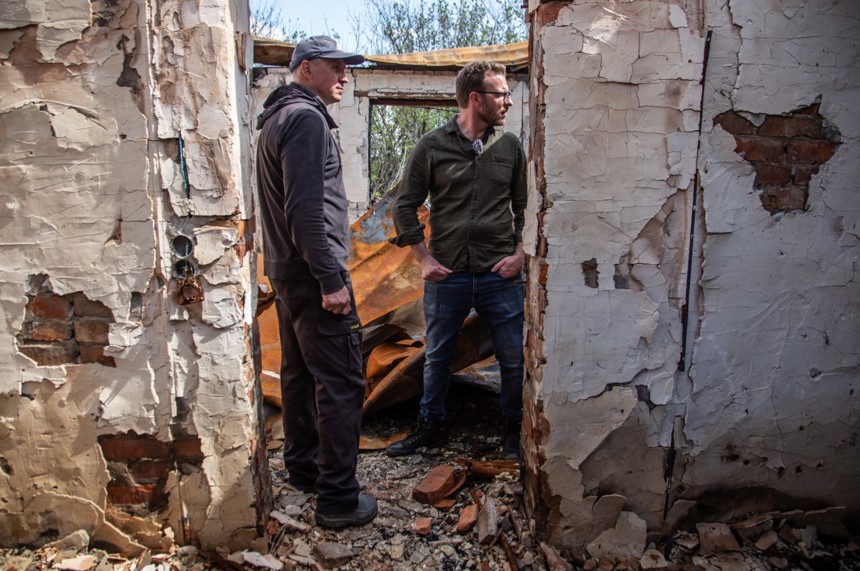 JJ Chalmers and Vyacheslav stand in the ruins of his former home